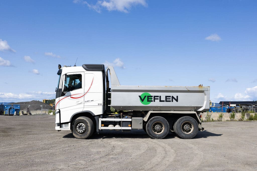 Veflen tippelastebil sett fra siden, parkert under blå himmel