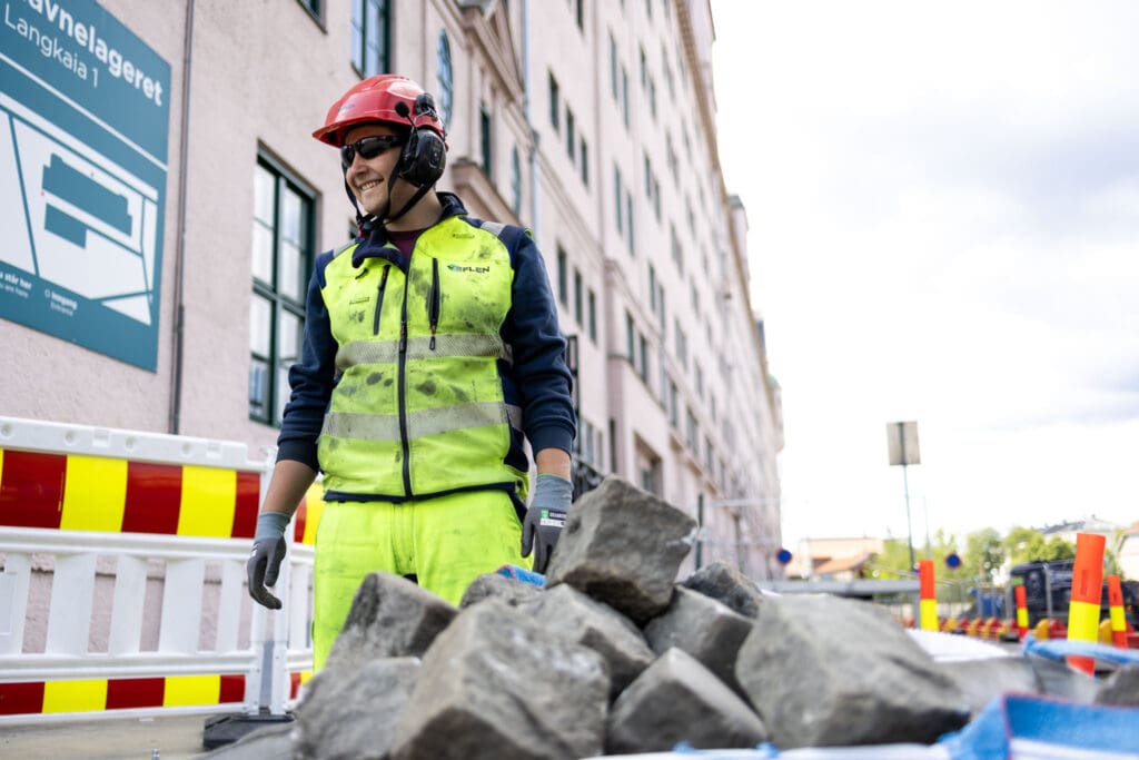 Jakob Fossen håndterer steinblokker under arbeid hos Veflen Entreprenør.